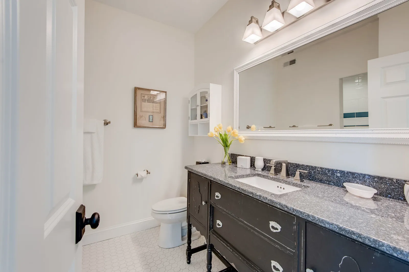 Bathroom with a dark furniture-style vanity and a speckled grey Cambria Waterford top